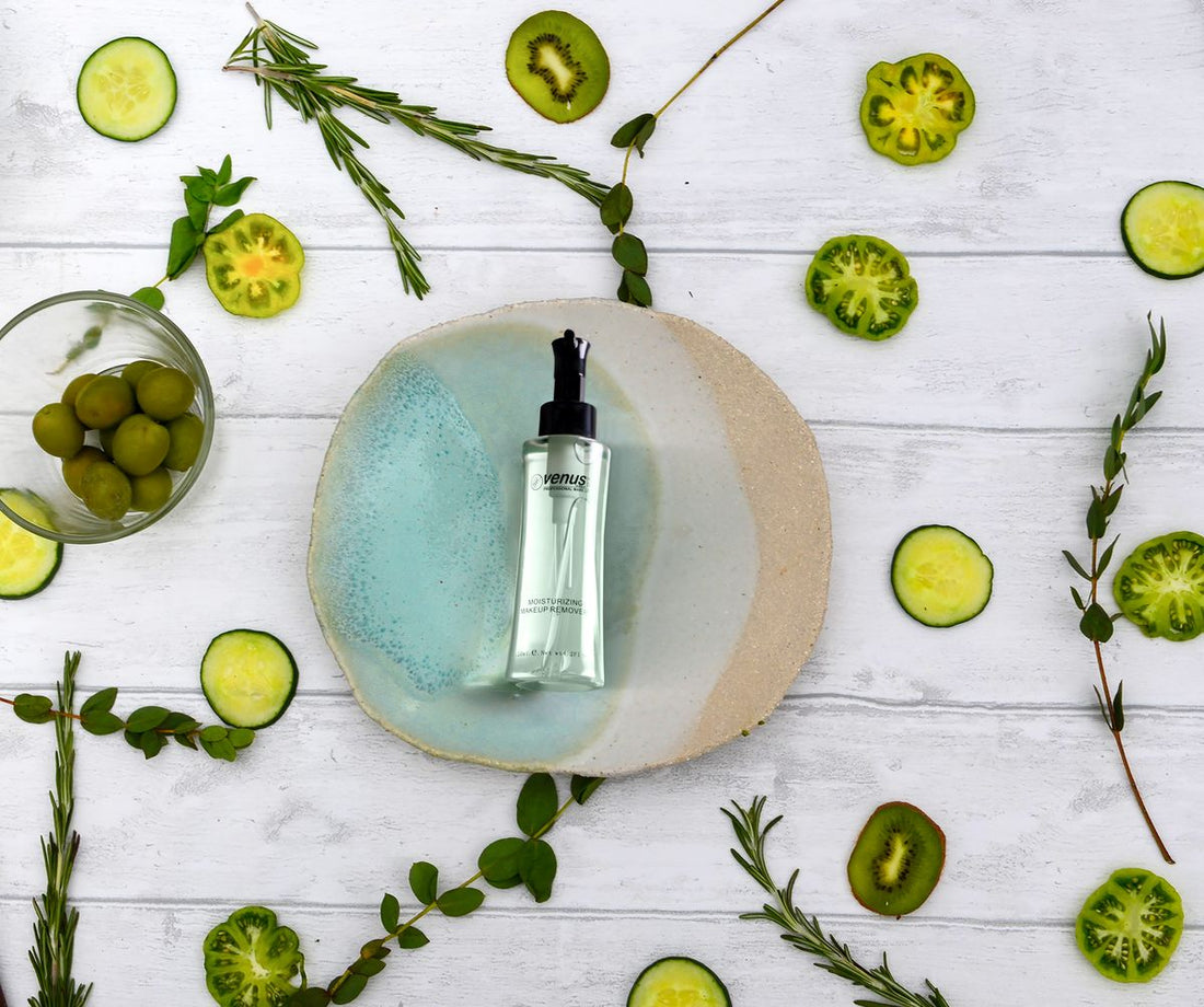 Skincare serum bottle on a wooden table surrounded by fresh cucumber slices and herbs
