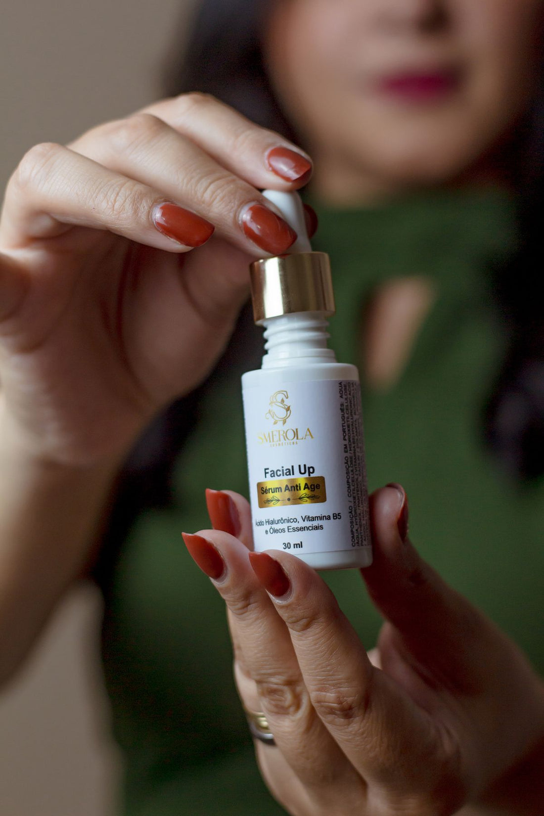 Close-up of a woman's hand holding a serum bottle as part of a vitamin C skincare routine for pigmentation