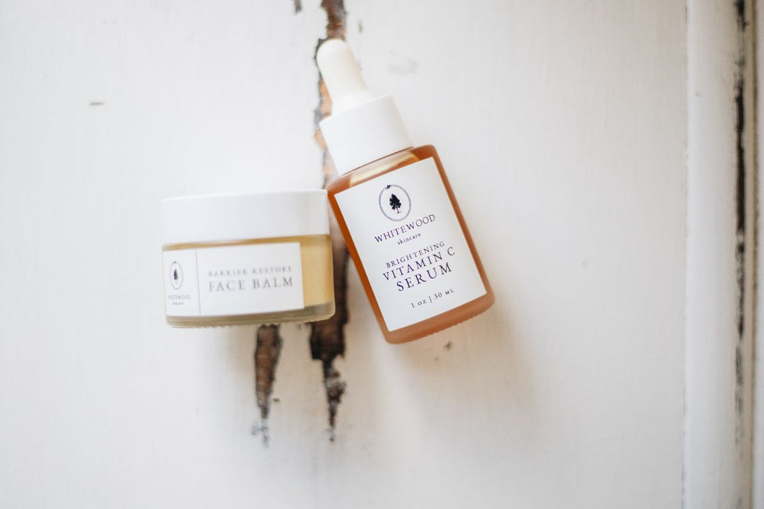 Flat lay of minimalist skincare serum and skincare products with natural botanical elements